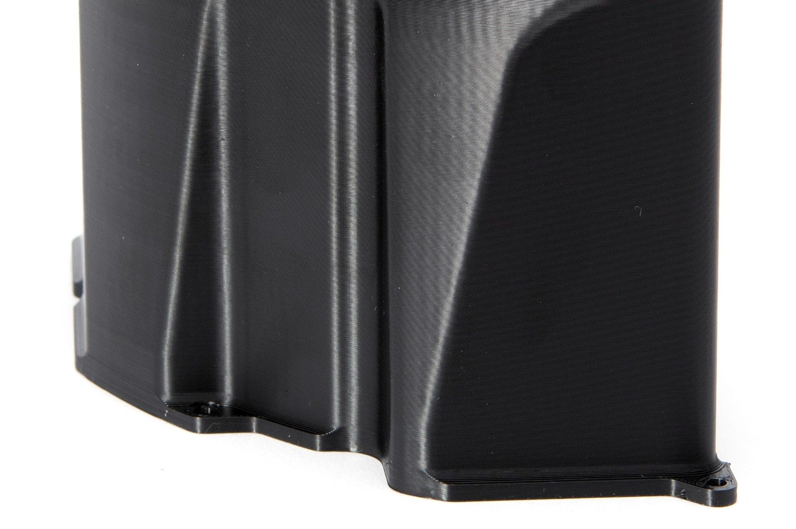 Corner of a printed Carbon5D housing with mounting lugs, smooth curved surfaces