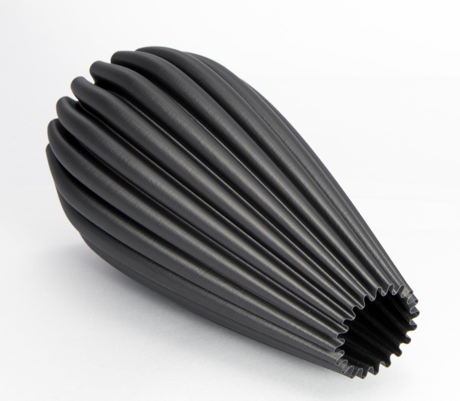 A fluted vase printed in Carbon5D ASA, lying on its side, matte as-printed finish