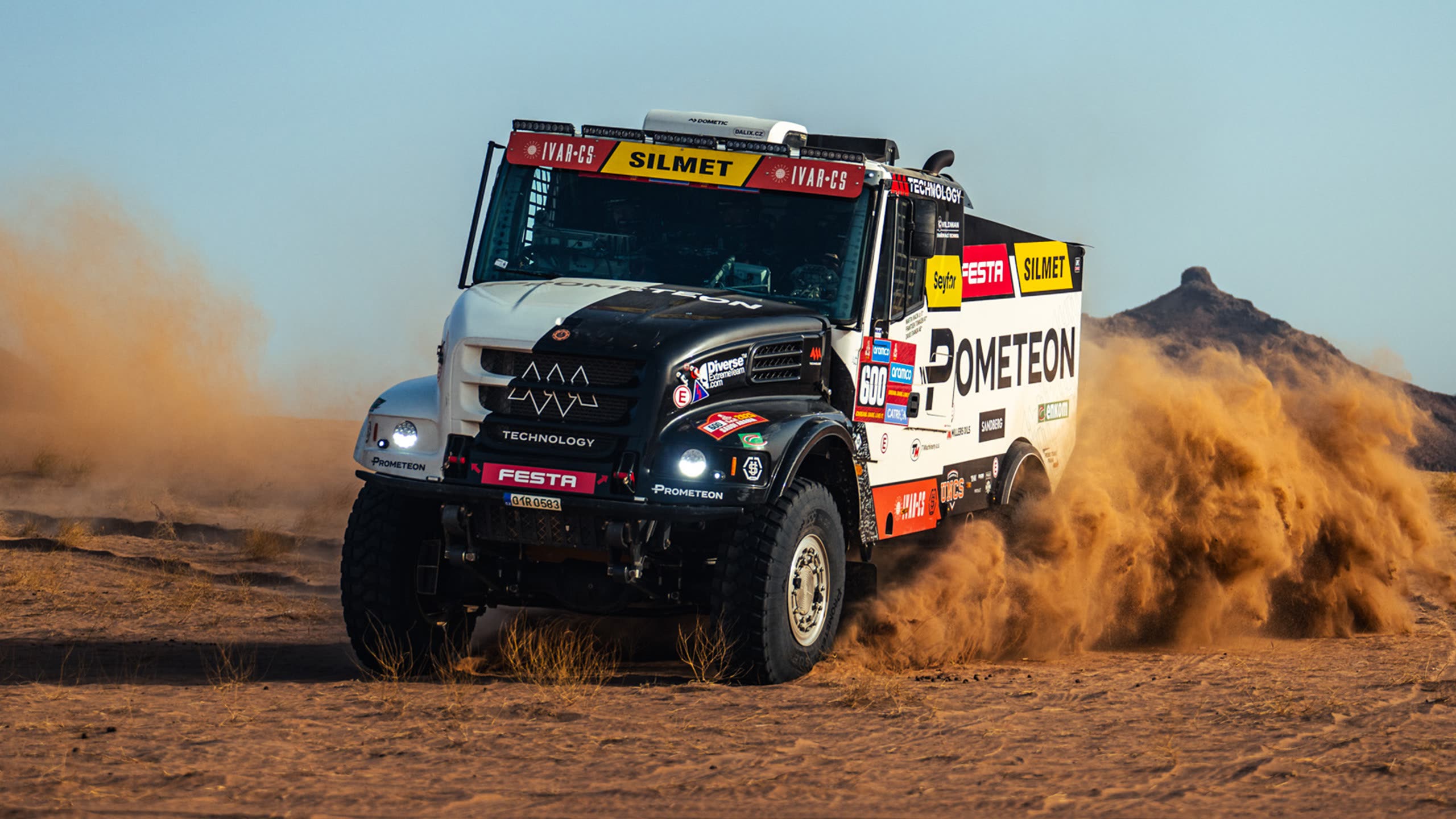 Prometeon Dakar rally truck head-on in a dust cloud
